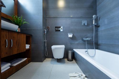 a bathroom with a shower and a toilet and a tub at Dream International Hotel in Lumbini