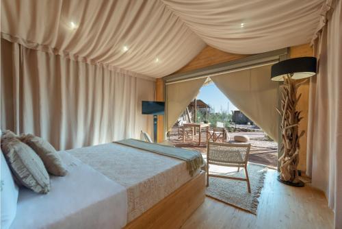 - une chambre avec un lit et une tente dans l'établissement Le Grancìe, à Porto Cesareo