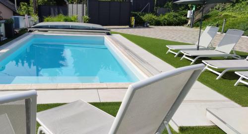 a swimming pool with lounge chairs and a group at AQUA SOLAR APARTMANHÁZ in Miskolc