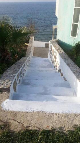 a staircase leading up to a house with the ocean at Villa Plage Ksar Sghir in Melîyech