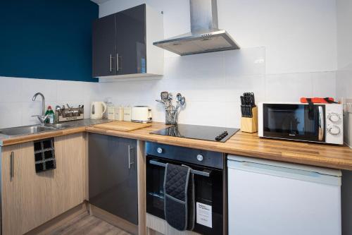 - une cuisine avec un comptoir et un four micro-ondes dans l'établissement Bank Street Apartment 9, à Blackpool