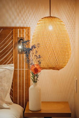 a lamp on a table with a vase with flowers at Renaissance Wind Creek Aruba Resort in Oranjestad