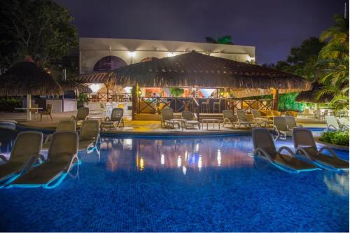 um resort com cadeiras e uma piscina à noite em Private Owned Suite at Coronado Luxury Suite Hotel & Golf Course em Playa Coronado
