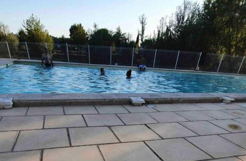 un groupe de personnes jouant dans une piscine dans l'établissement Belle Maisonette dans Residence 3* avec piscine partagée, à Saint-Saturnin-lès-Avignon