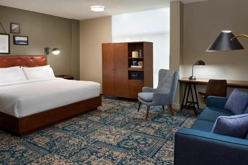 um quarto de hotel com uma cama, uma secretária e uma cadeira em Four Points by Sheraton Toronto Airport em Mississauga