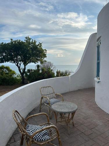 two chairs and a table on a patio with the ocean at Residenza Gherly in Capo Vaticano