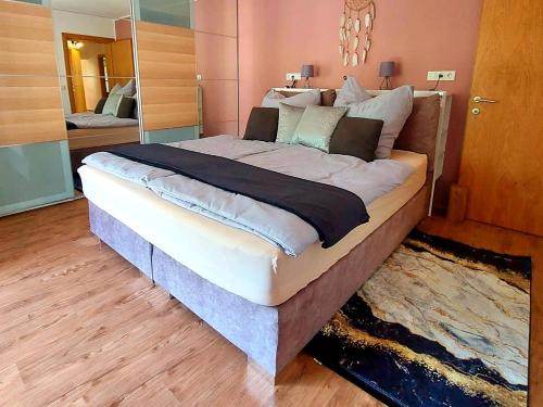 ein großes Bett in einem Schlafzimmer mit einem großen Spiegel in der Unterkunft Ferienhaus Goldener Anker Unterach am Attersee in Unterach am Attersee