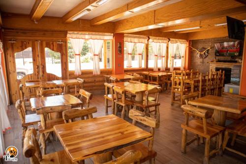um restaurante vazio com mesas e cadeiras de madeira em TARAMURI HOTEL & TOURS em Creel