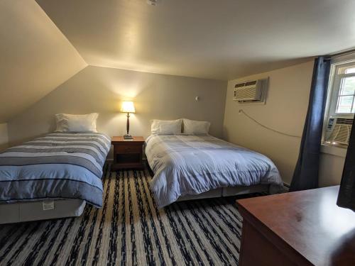 a hotel room with two beds and a table with a lamp at Perry's Motel and Cottages in North Conway