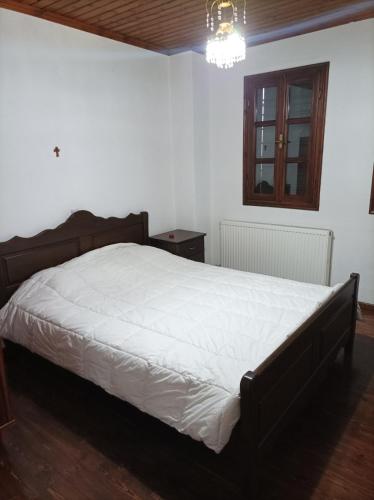 a bedroom with a large bed with white sheets at House Christina in Palaioi Poroi