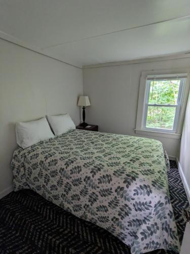 a bedroom with a bed and a window at Perry's Motel and Cottages in North Conway
