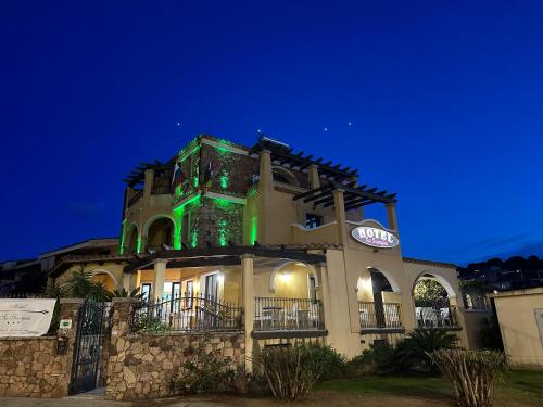 un bâtiment avec des lumières vertes au-dessus dans l'établissement Hotel Sa Suergia, à Villasimius