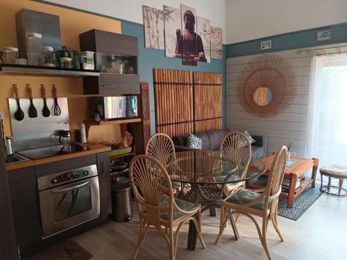 a kitchen with a table and chairs in a kitchen at Little bouddha in Hermanville-sur-Mer