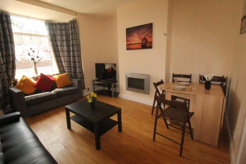 a living room with a couch and a table with a table at Lundwood House Barnsley by Smart Corporate Stays in Barnsley