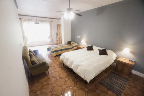 1 dormitorio con 1 cama, 1 sofá y 1 silla en Estancia Santa Elena en Villa Lía