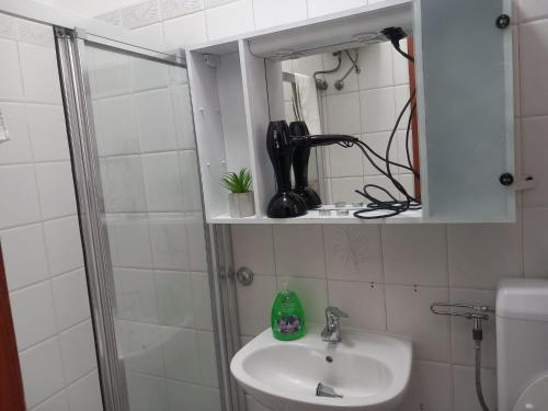La salle de bains est pourvue d'un lavabo et d'une douche. dans l'établissement Holiday house in Siniscola, à Siniscola