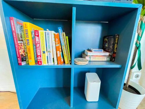 a blue book shelf filled with books and a speaker at IB Seaside Paradise w/ Ocean Views! in Imperial Beach