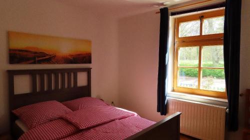 Schlafzimmer mit einem Bett und einem Fenster in der Unterkunft Ferienwohnung "Specker Krug" in Kargow