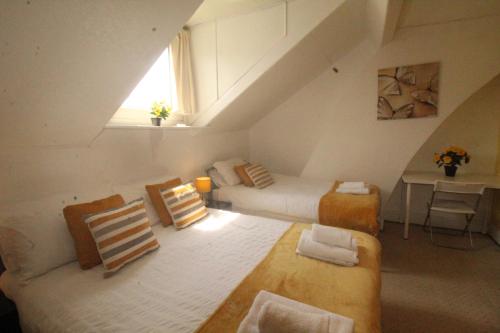 a attic room with two beds and a couch at Lundwood House in Barnsley