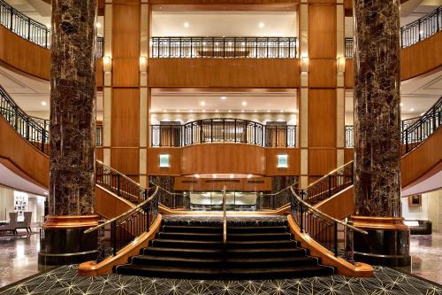 a staircase in a building with two palm trees at Sheraton Grand Sydney Hyde Park in Sydney
