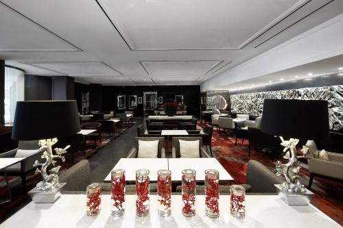 a restaurant with tables and chairs in a room at Sheraton Grand Sydney Hyde Park in Sydney