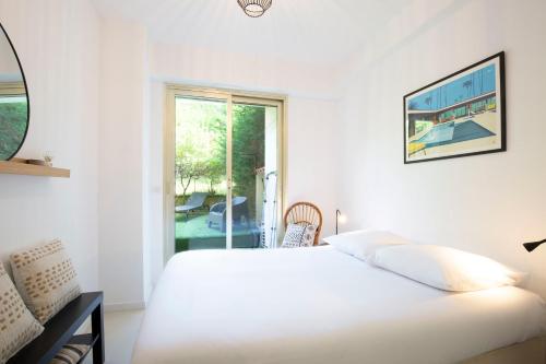 Habitación blanca con cama y ventana en WE CANNES ! Exceptional 4 rooms apartment Cannes Center swimming pool, en Cannes