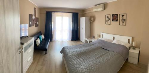 1 dormitorio con 1 cama y TV en SunSet Beach Apartman, en Balatonfűzfő