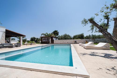 una piscina con tumbonas y una casa en Villa Bianca - Private swimming pool - Center - by ClickSalento, en Ostuni