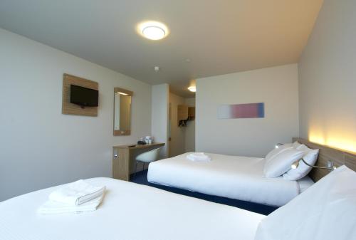 a hotel room with two beds and a tv at Travelodge Limerick Castletroy in Limerick