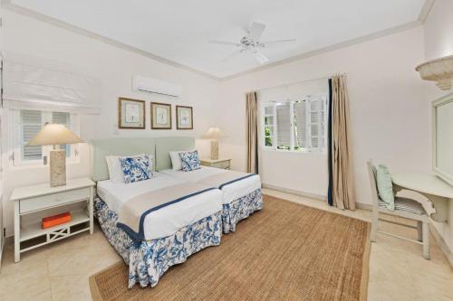 a white bedroom with a bed and a desk and a window at Royal Westmoreland - Villa Rosa by Island Villas in Saint James
