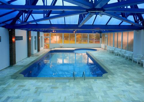 a large swimming pool with a blue ceiling at Colonial Plaza Hotel Pindamonhangaba in Pindamonhangaba