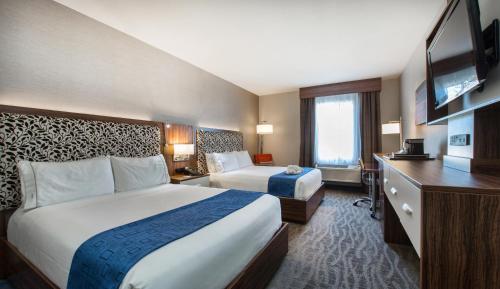 a hotel room with two beds and a flat screen tv at Holiday Inn Express Redwood City Central, an IHG Hotel in Redwood City