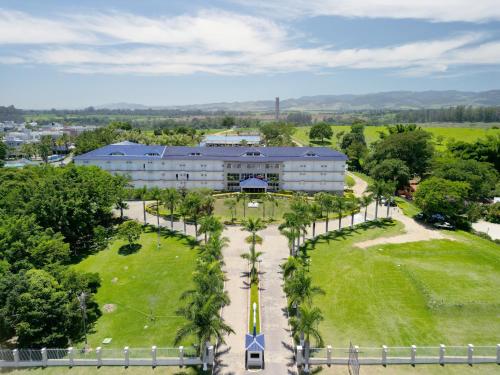 an overhead view of a large building with palm trees at Colonial Plaza Hotel Pindamonhangaba in Pindamonhangaba