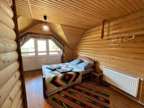 ヴェルホヴィナにあるPid Yasenemの木造キャビン内のベッド1台が備わるベッドルーム1室を利用します。