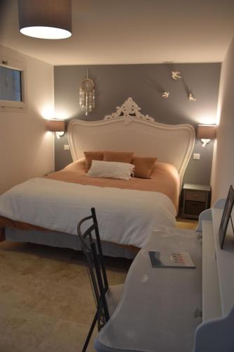 - une chambre avec un grand lit blanc, une table et des chaises dans l'établissement Dbarka7, à Sète