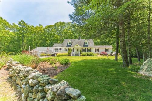 a large white house with a stone wall at Cozy Bungalow Just Minutes from Mystic, Westerly Beaches, Boating and Casinos! bungalow in Groton