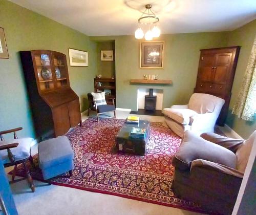 a living room with a couch and a fireplace at Cherry Grove Welsh Farmhouse in Pembrokeshire