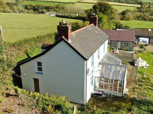an aerial view of a white house in a field at Cherry Grove Welsh Farmhouse in Pembrokeshire