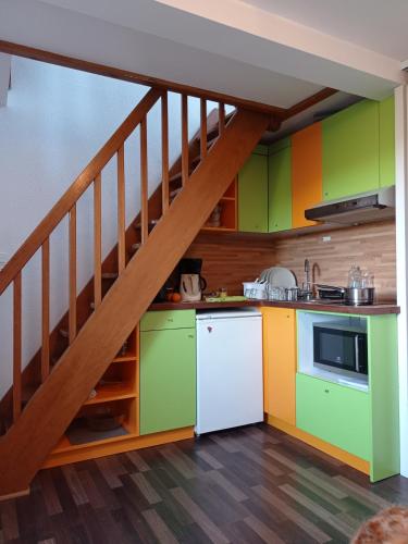une cuisine avec des armoires colorées et un escalier dans l'établissement Appartement Plage de Kerfany les Pins, à Kerfany-les-Pins