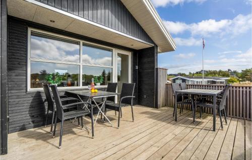 a patio with a table and chairs on a deck at Kis in Fanø