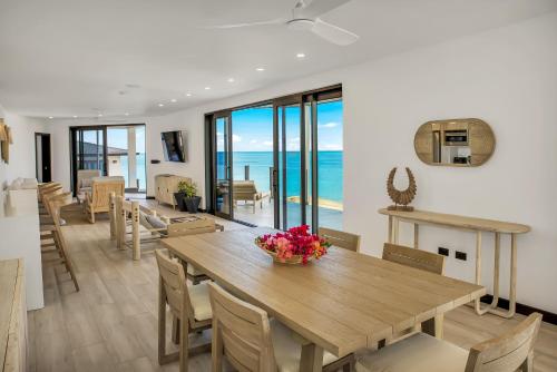a dining room with a table and chairs and the ocean at Tamarind Hills Resort & Villas in Johnsons Point