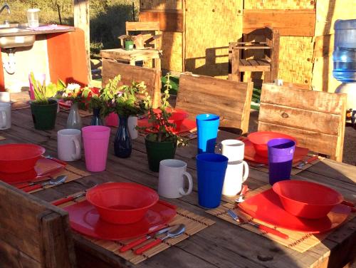 a wooden table with red and blue cups and plates at Sunset Paradise - Todos Santos in Todos Santos