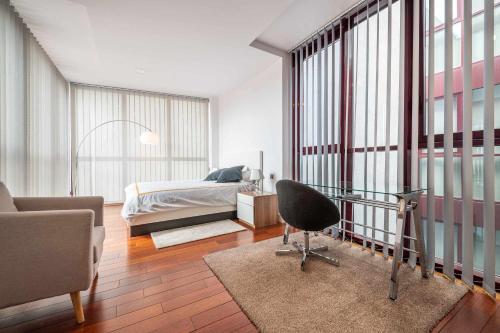 a bedroom with a bed and a desk and a chair at Chueca Gran Via Recoletos Libertad 24 12 in Madrid