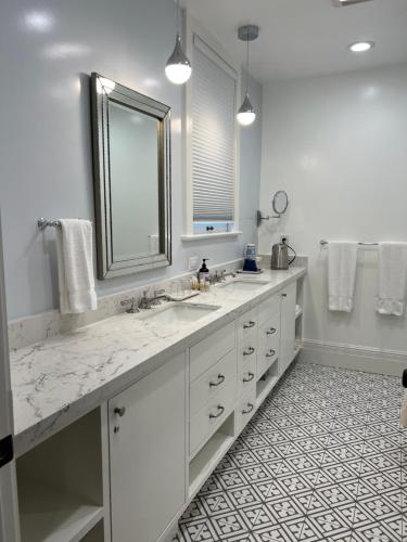 a white bathroom with two sinks and a mirror at Cowper Inn in Palo Alto