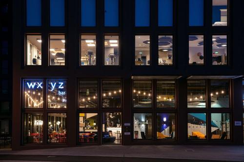 a large building with many windows at night at Aloft Strasbourg City Centre in Strasbourg