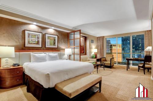 a hotel room with a large bed and a desk at MGM Signature-27-805 F1 Track & Strip View Balcony in Las Vegas