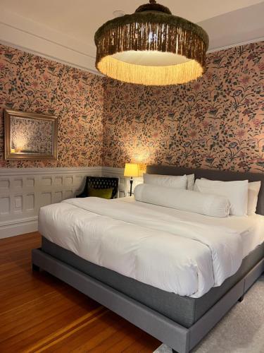 um quarto com uma cama grande e um lustre em Cowper Inn em Palo Alto