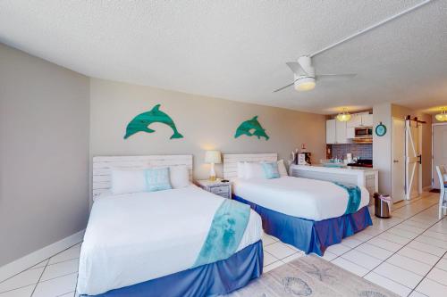 1 dormitorio con 2 camas con delfines en la pared en Top of the Gulf Experience en Panama City Beach