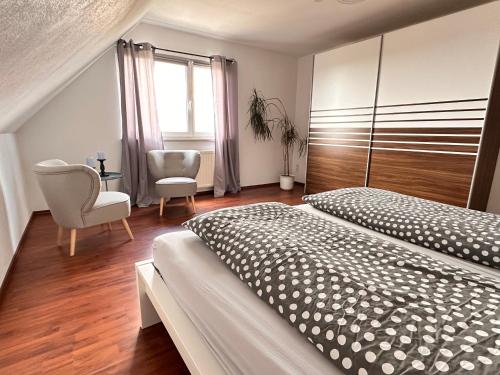 ein Schlafzimmer mit einem Bett, einem Stuhl und einem Fenster in der Unterkunft Ferienwohnung Harzdomizil in Gernrode - Harz