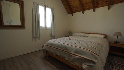 1 dormitorio con cama y ventana en Casa 5 personas SMA en San Martín de los Andes